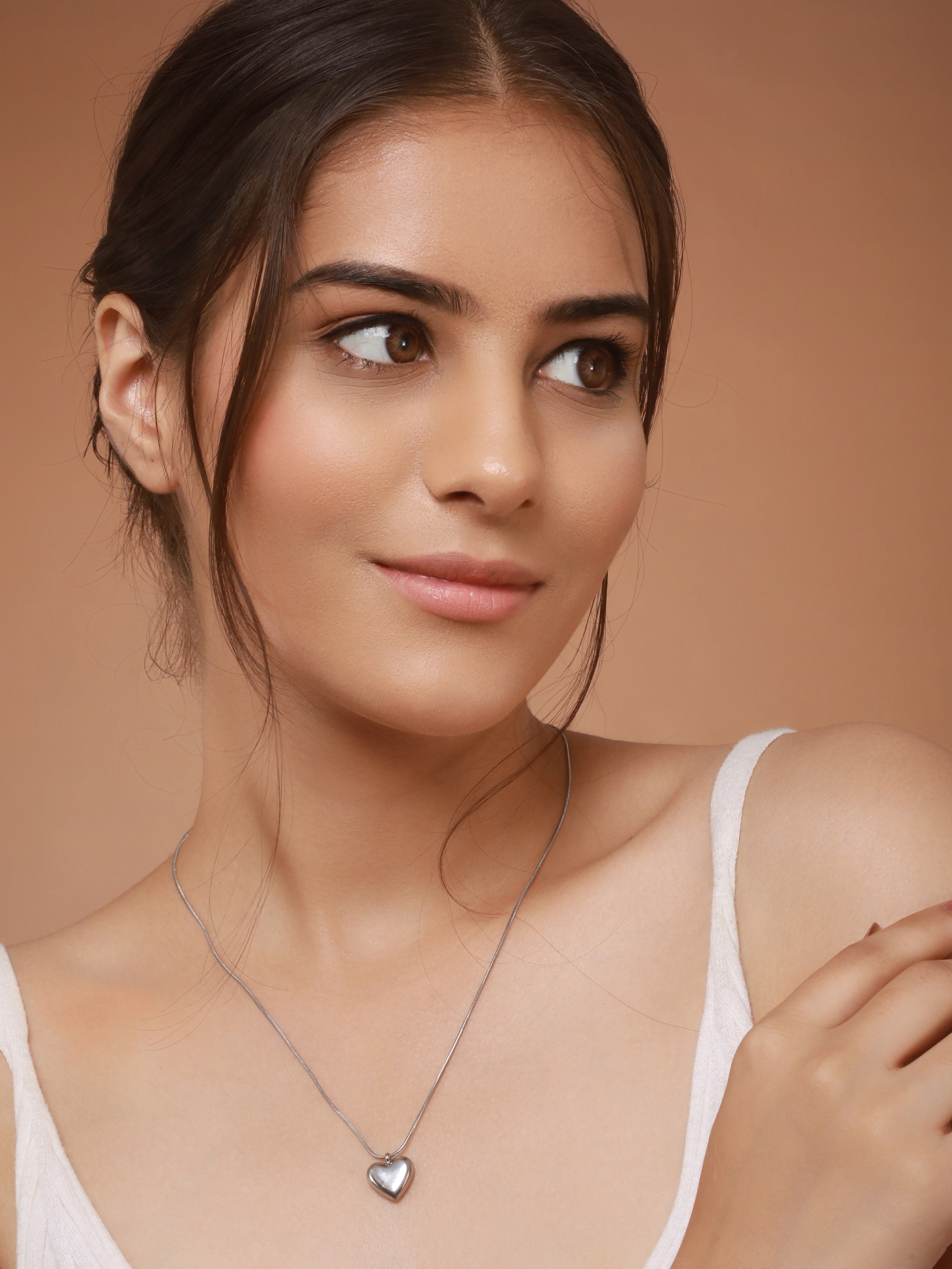 In the image, the model is wearing silver plated Heart Pendant Necklace