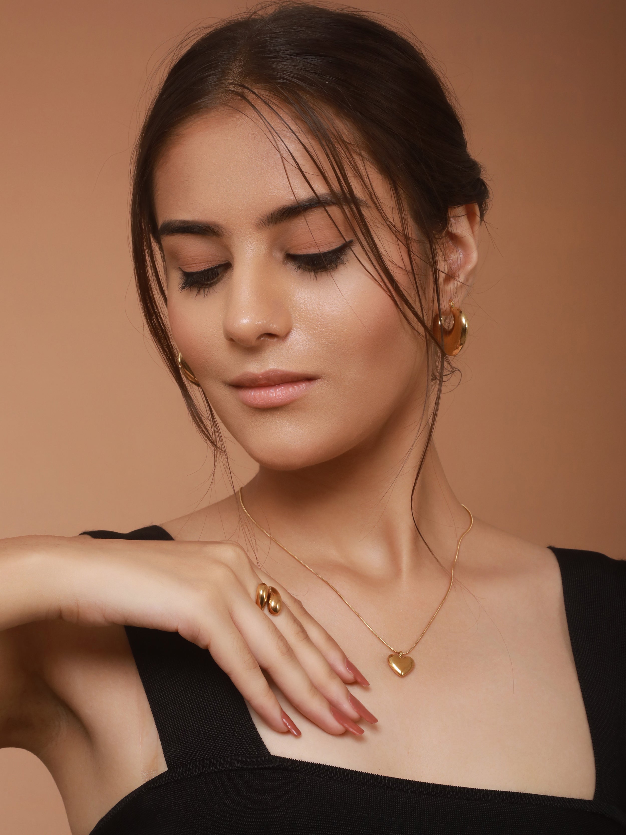 A model is featuring Akoya's jewelry collection of necklace, earrings, and ring