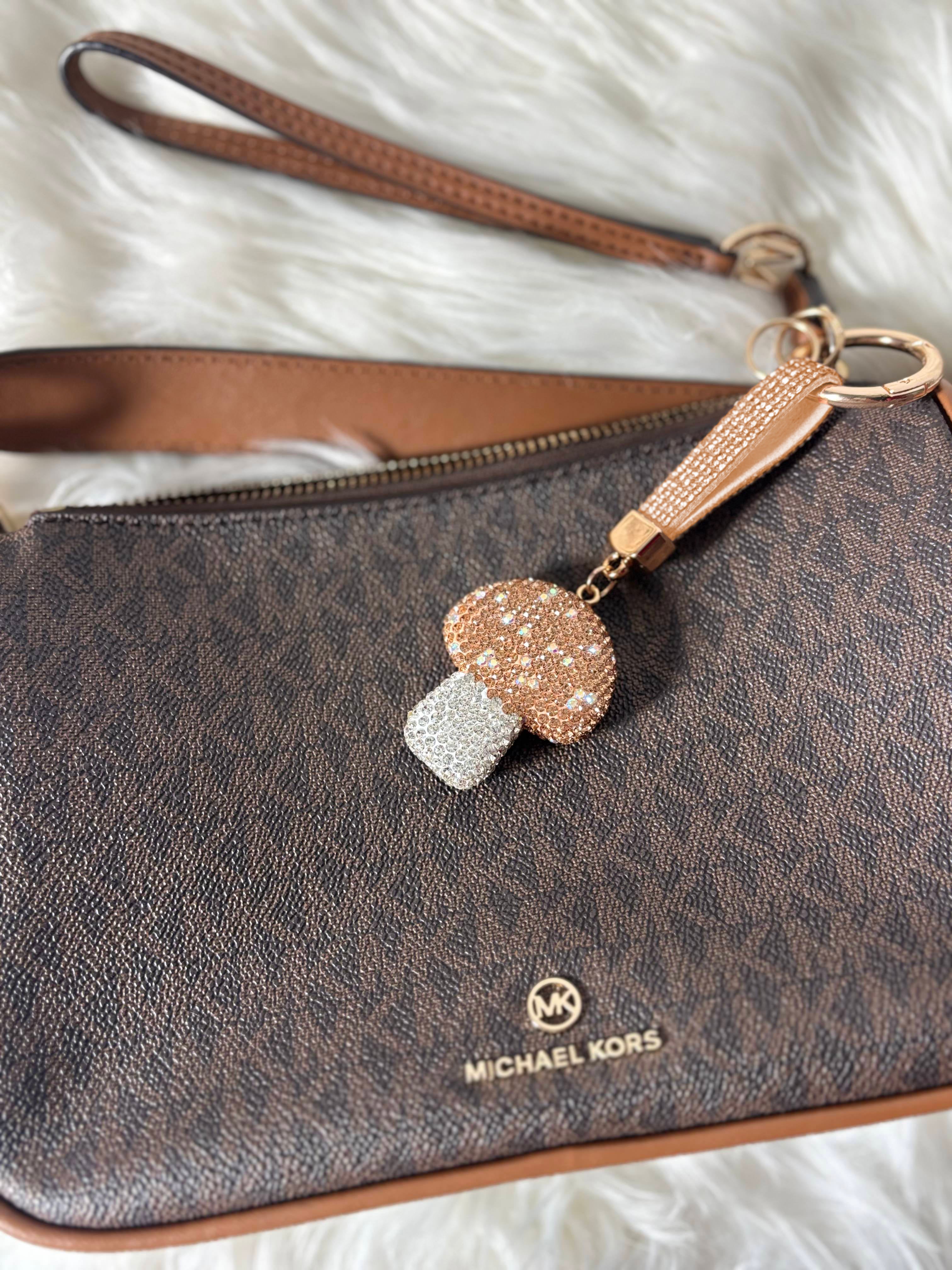 The image illustrates Michael Kors bag with Golden Shroom Keychain of Zelci