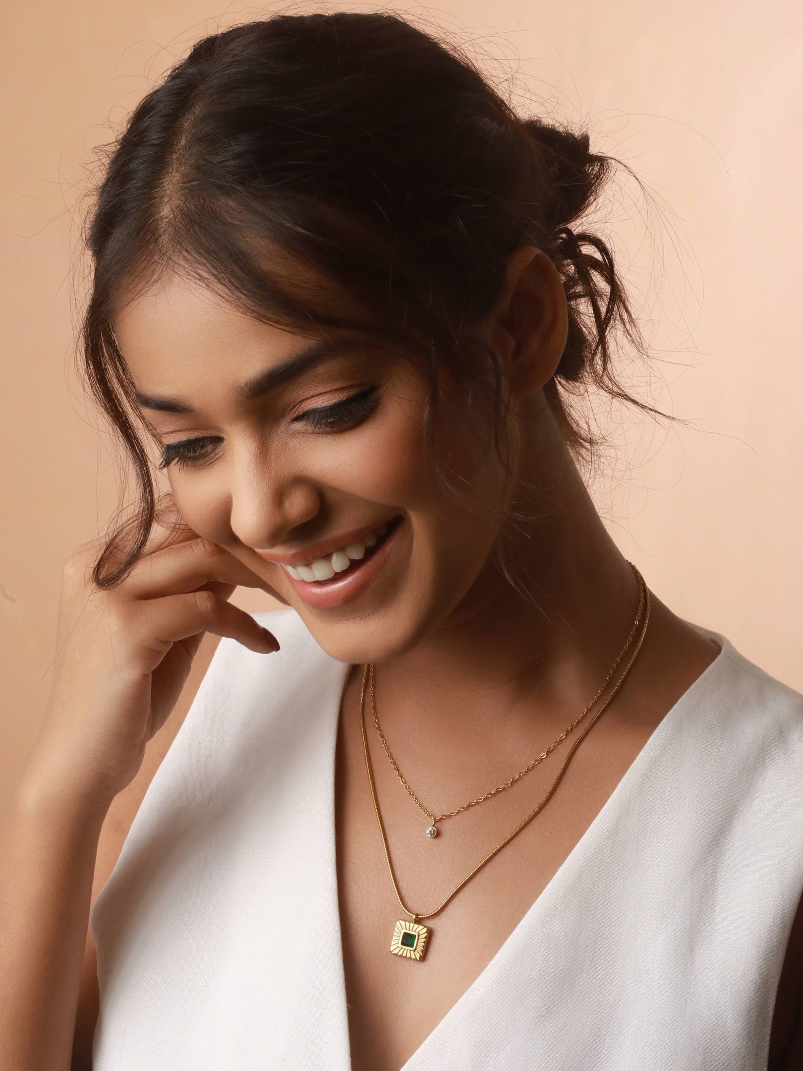 The image features smiling face of a model, wearing Emerald Radiance Necklace