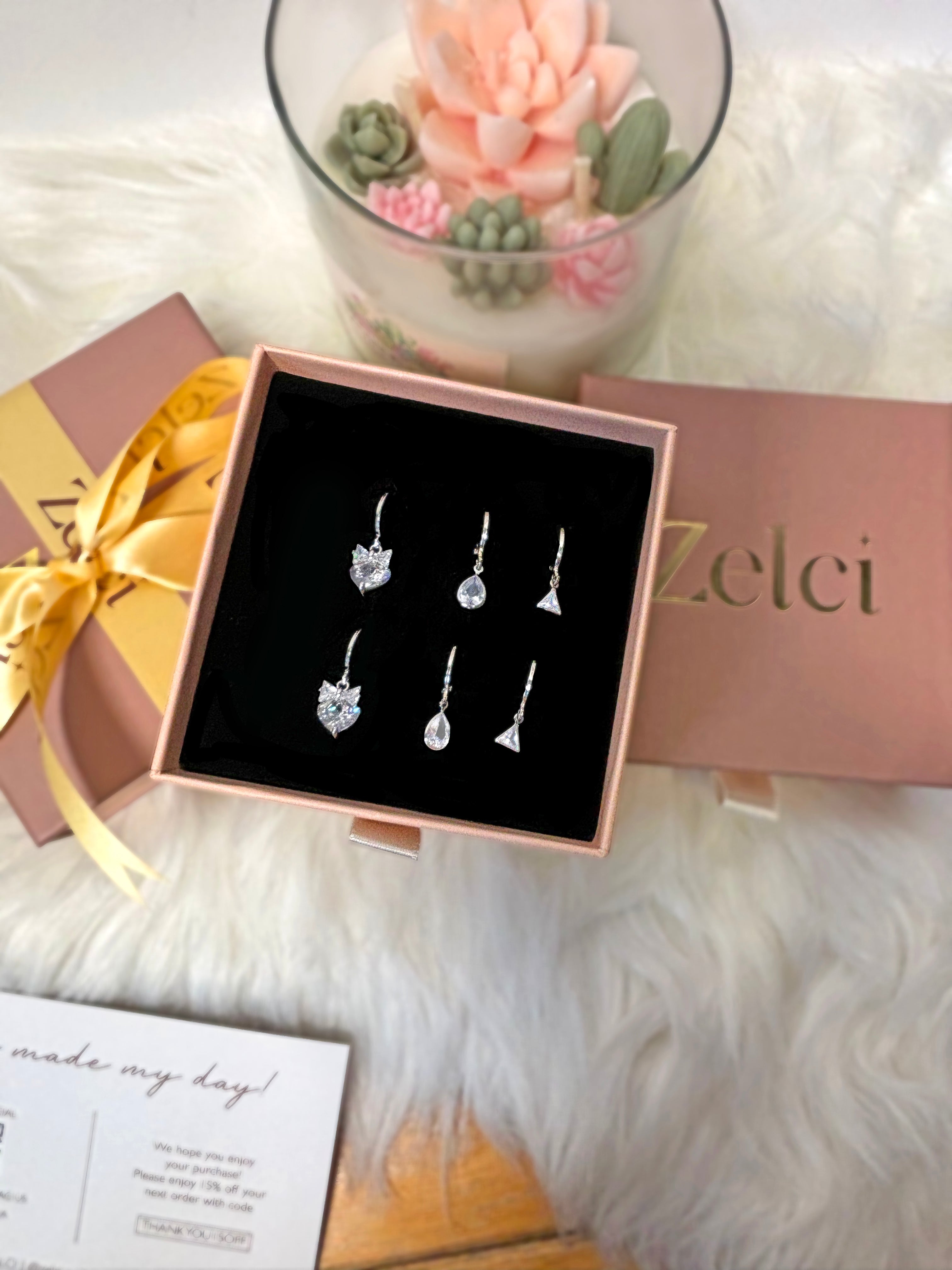 A decorative box showcases Zelci’s Bowtiful Trio set in the frame