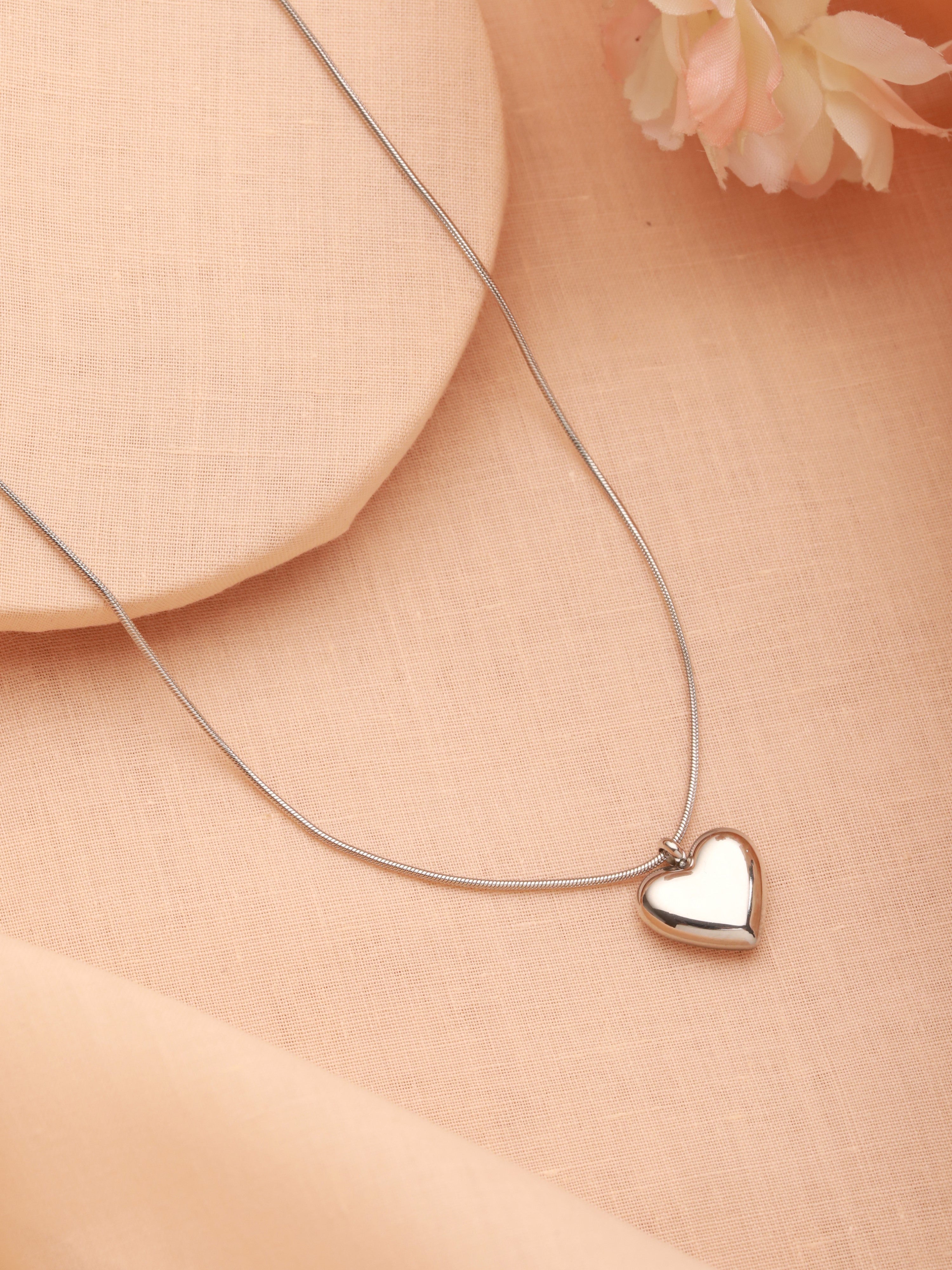 The silver plated Heart Pendant Necklace is shown in a beautiful background