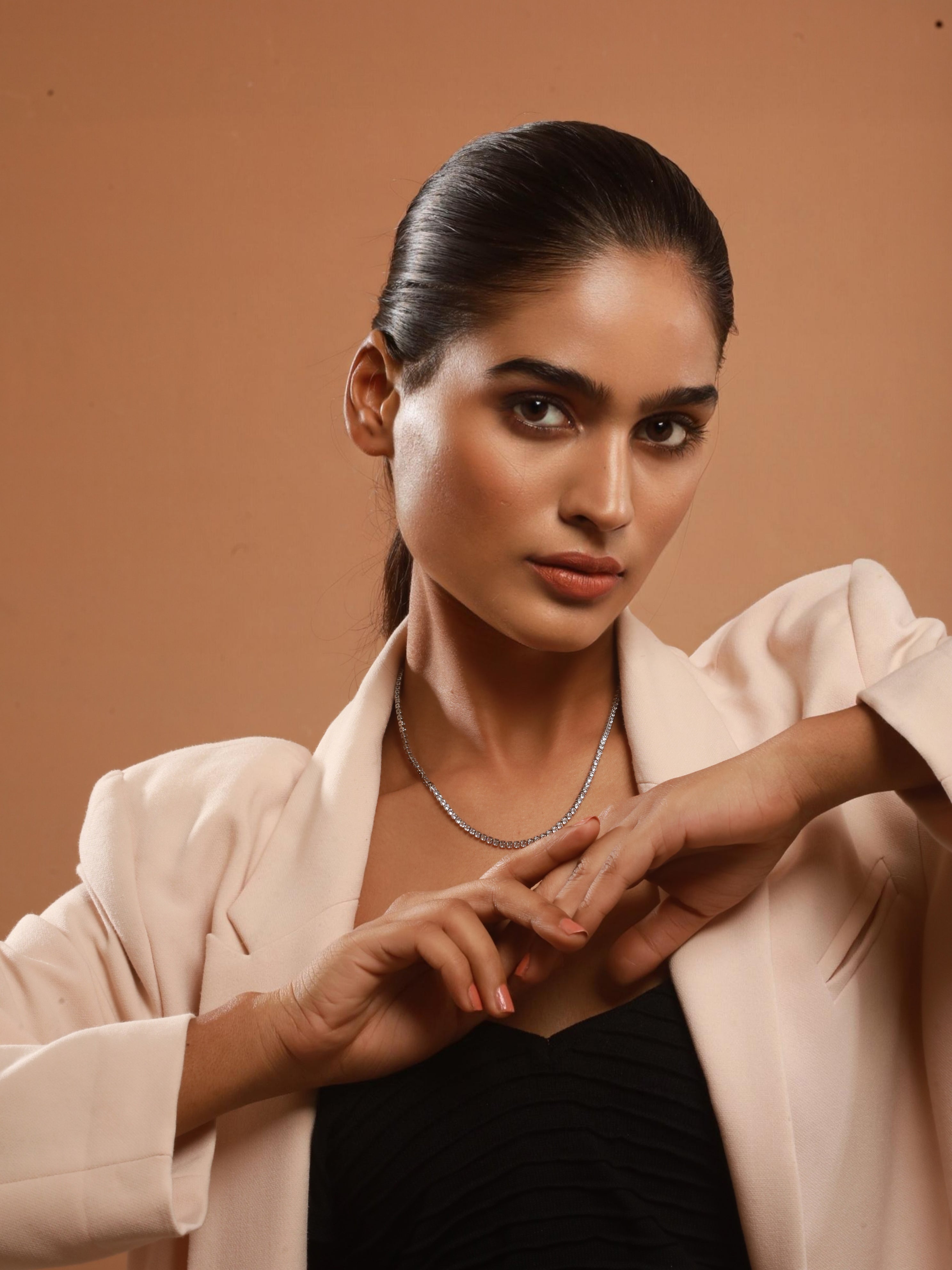 The model highlights the charm of Zelci’s Midnight Luxe Necklace