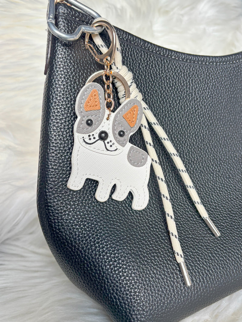The zoomed in view of Zelci's Pawfect Keychain, hanging on COACH bag