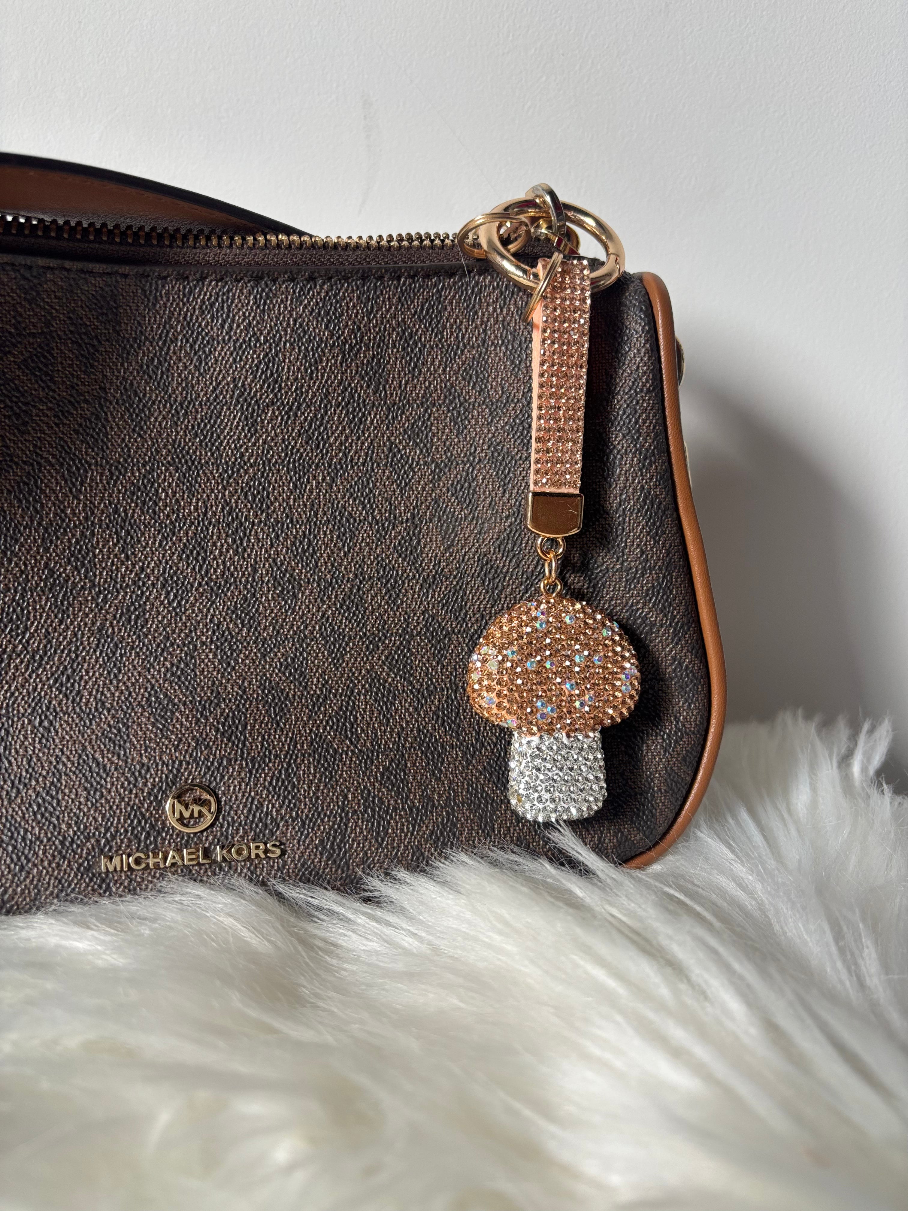 Golden Shroom Keychain of Zelci is hanging on a bag 