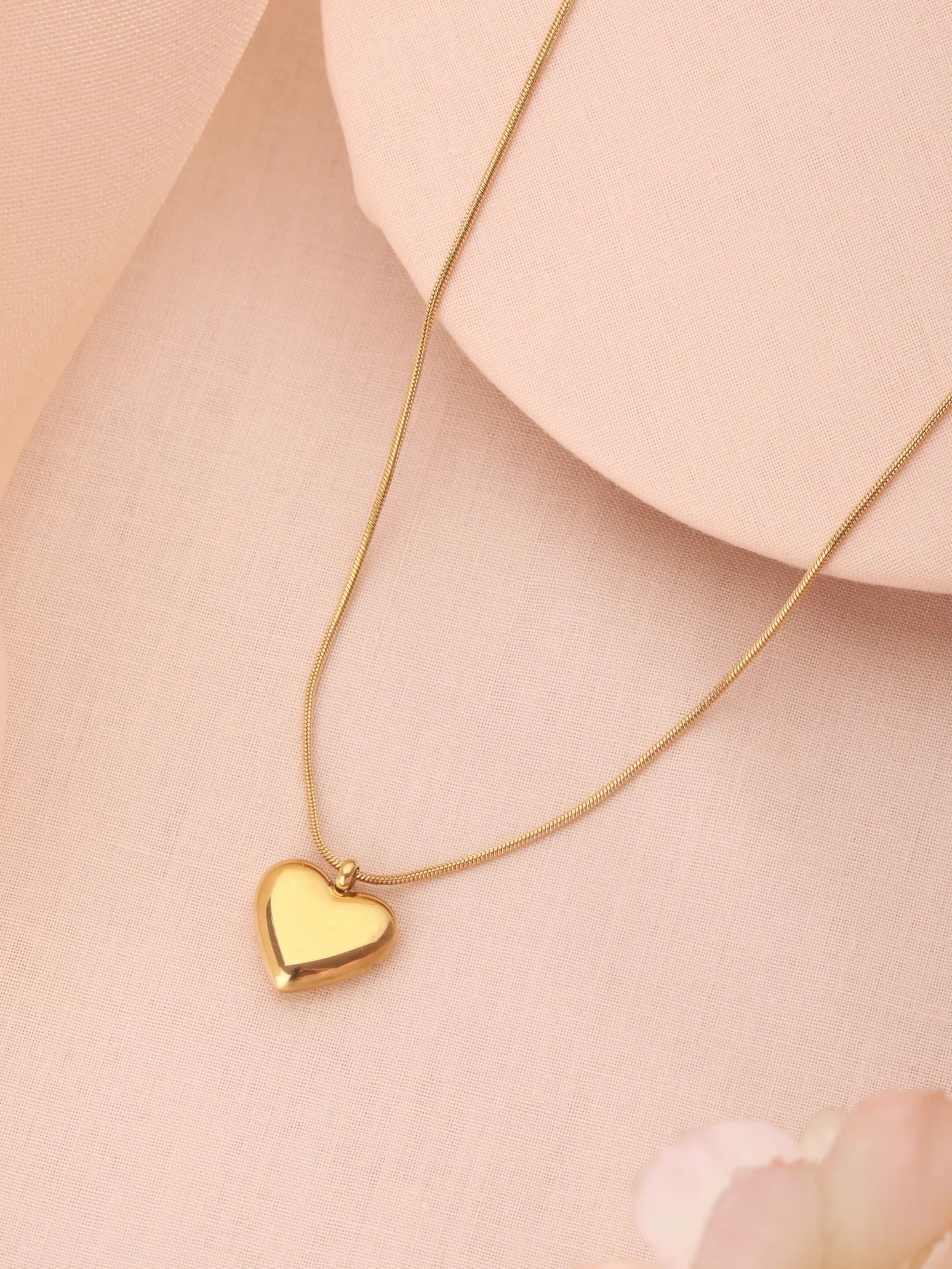 Gold-plated heart pendant necklace of the Zelci's Harmony Set has been presented on a stylish background