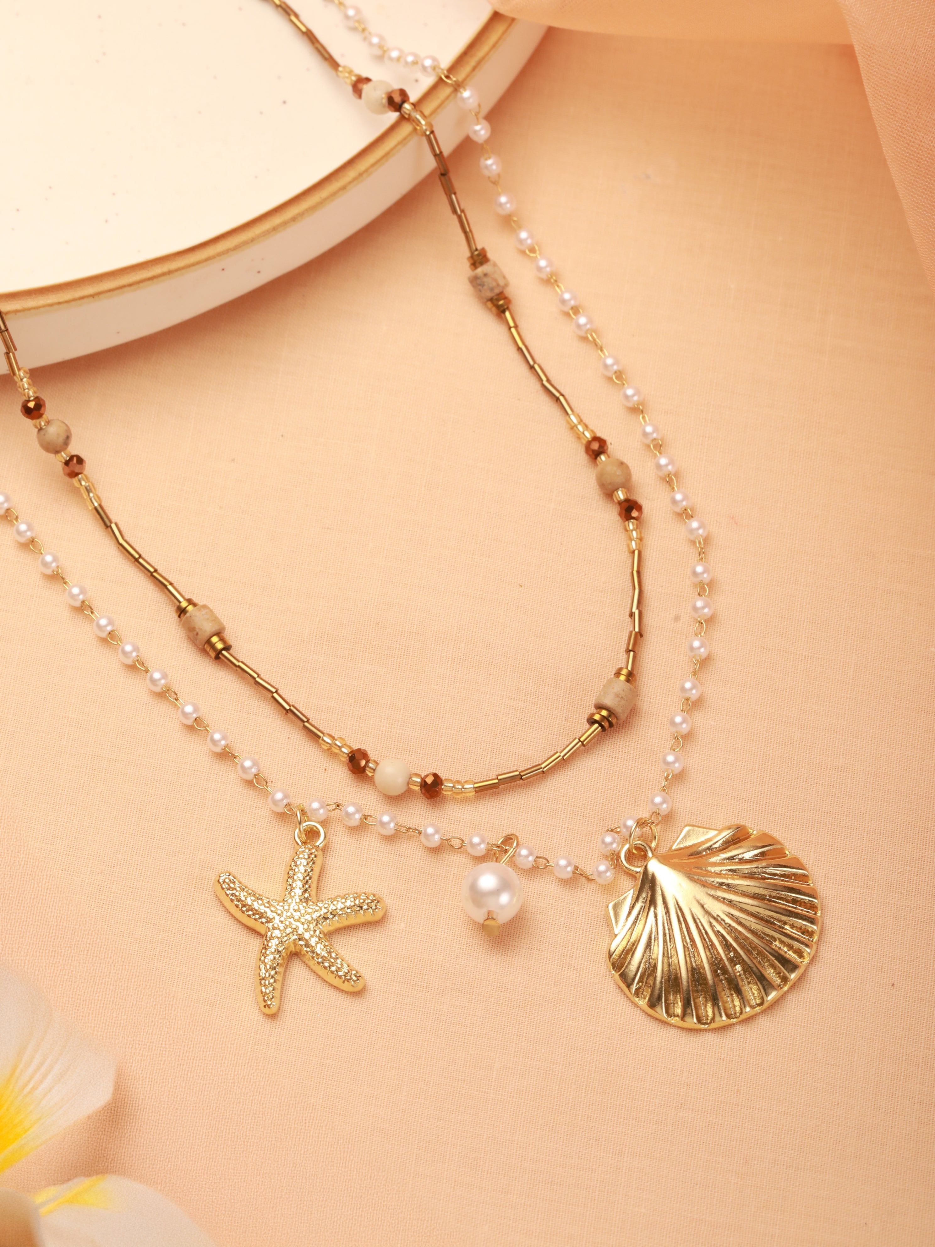 The dual-layer Coastal necklace has been showcased on a cream colour background