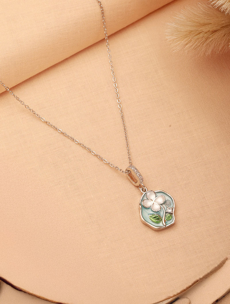 Set against a vibrant background, Zelci’s Petaline Pendant takes center stage